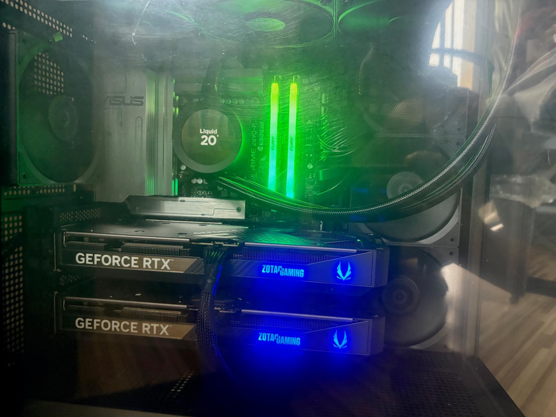 Inside one of the stations: two ZOTAC GeForce RTX cards stacked on an ASUS PRIME board, green-lit Fury memory, and a liquid cooler reading 20 degrees.
